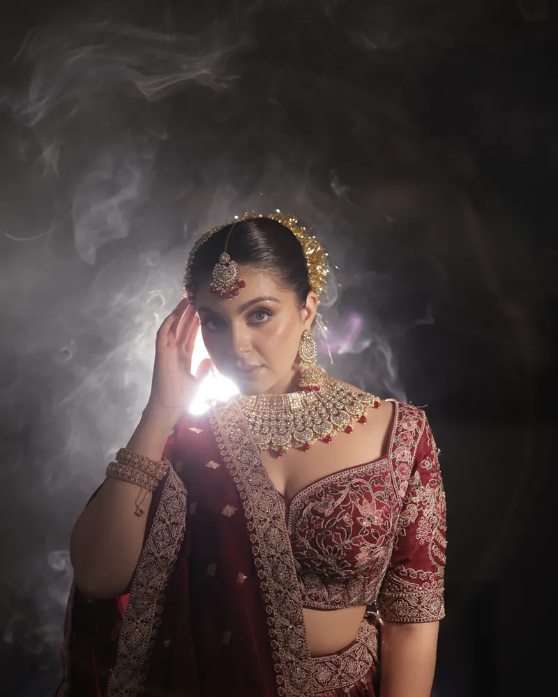 Bride in an ivory lehenga lit by fairy lights, makeup by Samia