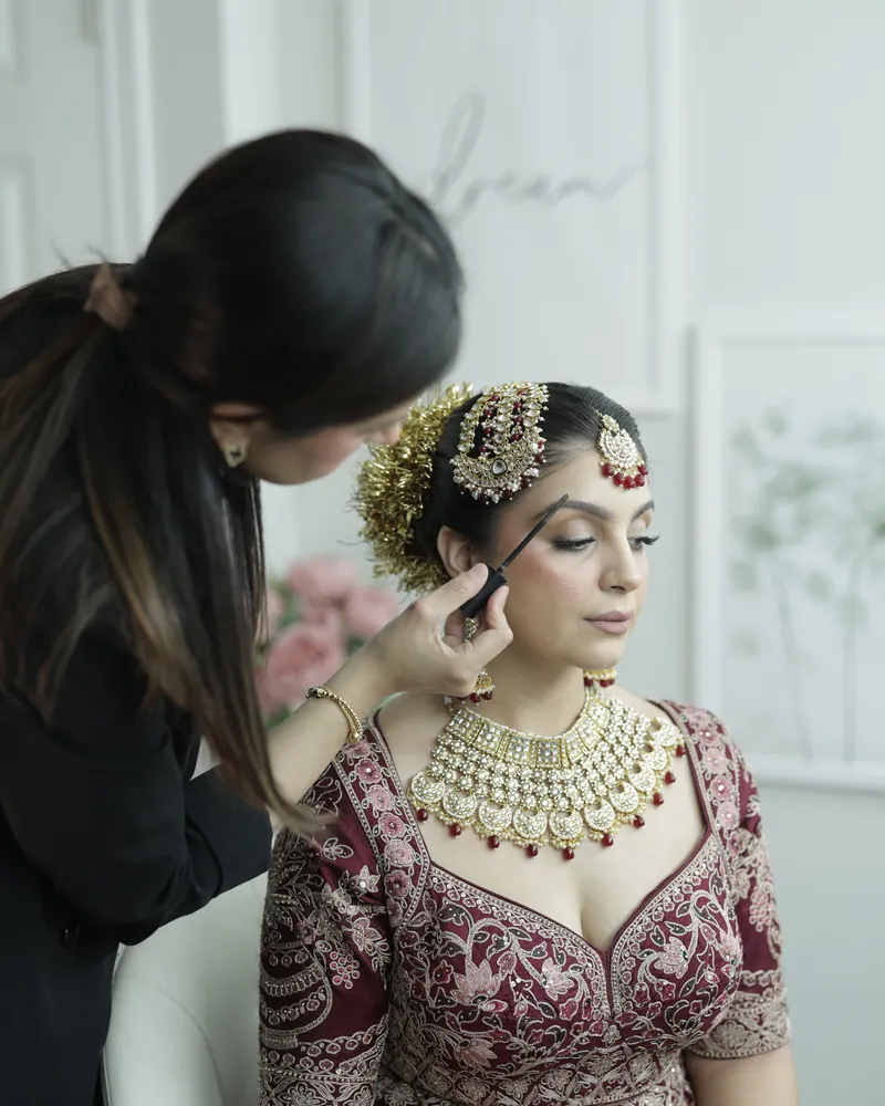Samia applying a bride’s makeup in her studio
