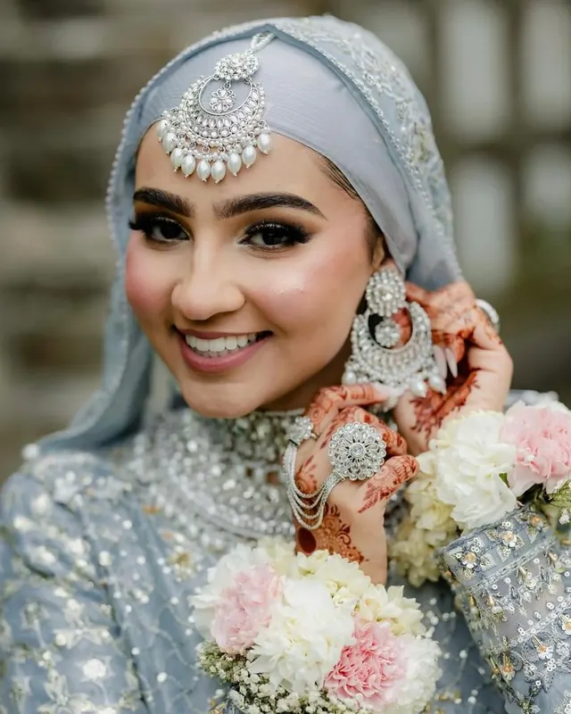 Hijab bride in ice blue with flowers, makeup by Samia